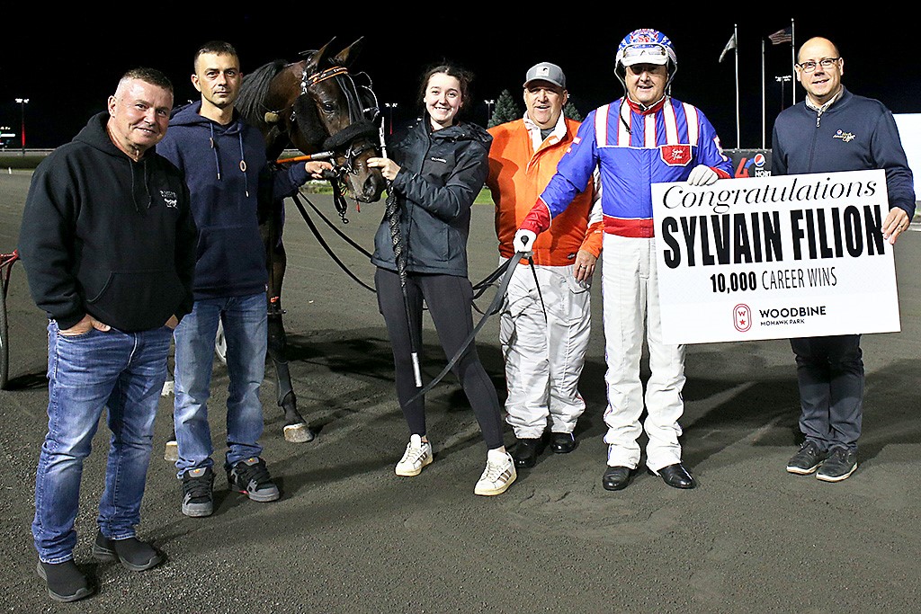 Sylvain Filion receives a sign of congratulations from Bill McLinchey, Vice-President of Standardbred Racing, following his 10,000th career win. (New Image Media).