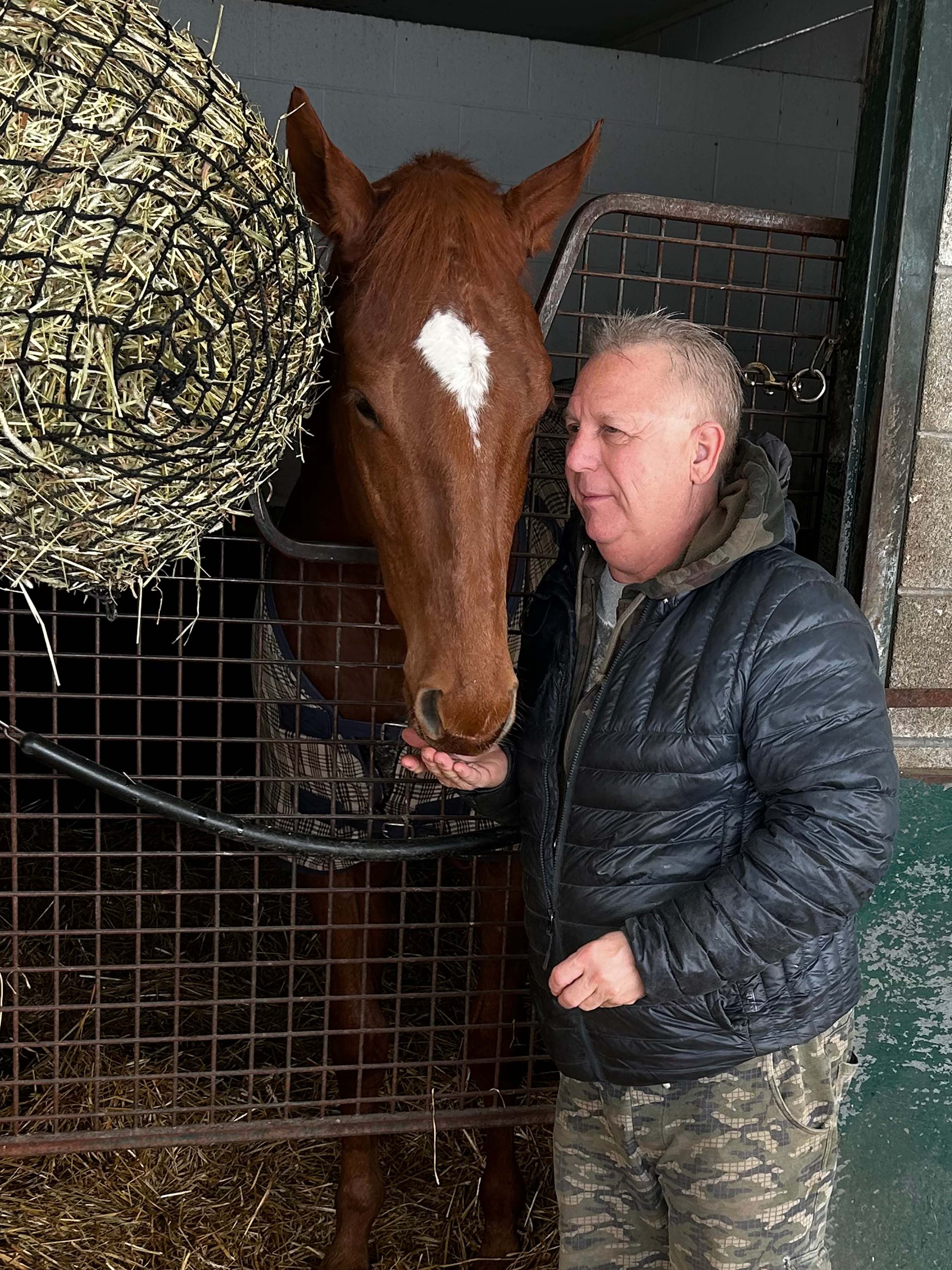 Horse and trainer standing in front of a stall.