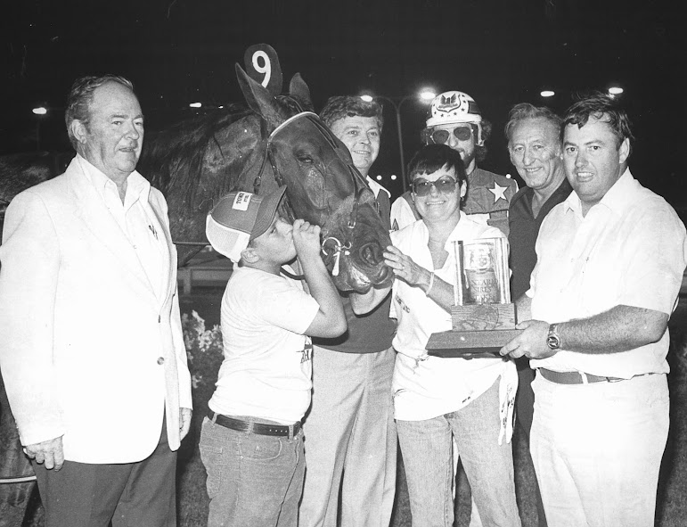 AM Playgirl, a filly pacer, is with part-owners Stew and Joanne Firlotte on the far right. Jack Graham is on the far left. Driver Doug Brown is in the background.