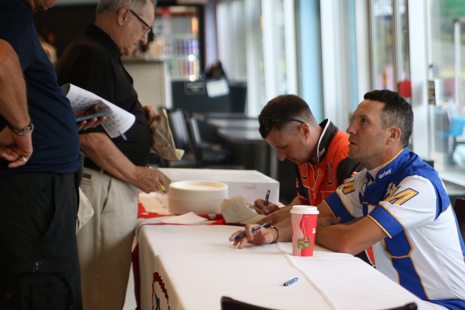 Drivers James MacDonald (right) and Tyler Borth (left) sign autographs at Rideau Carleton Raceway’s Ontario Sires Stakes 50th Anniversary celebration on June 23, 2024 (Ontario Racing photo)