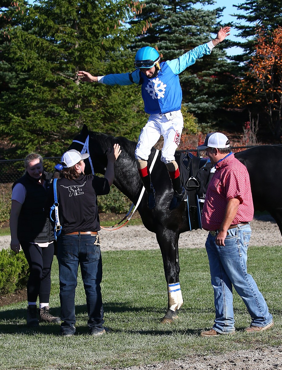 Champion Woodbine Thoroughbred jockey Rafael Hernandez leaps from Championship winner Maryland Magic.