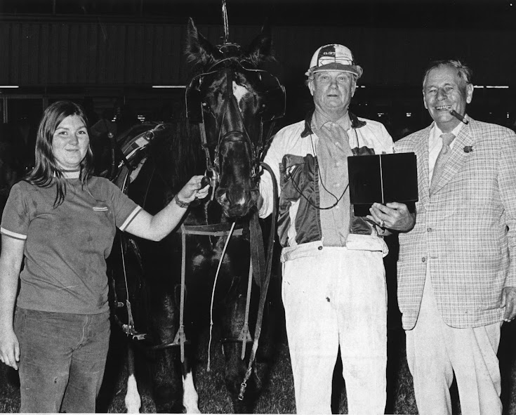 Pats Bye Bye and owner-driver and breeder Clint Hodgins are joined in the winner’s circle by Elgin Armstrong on the far right.